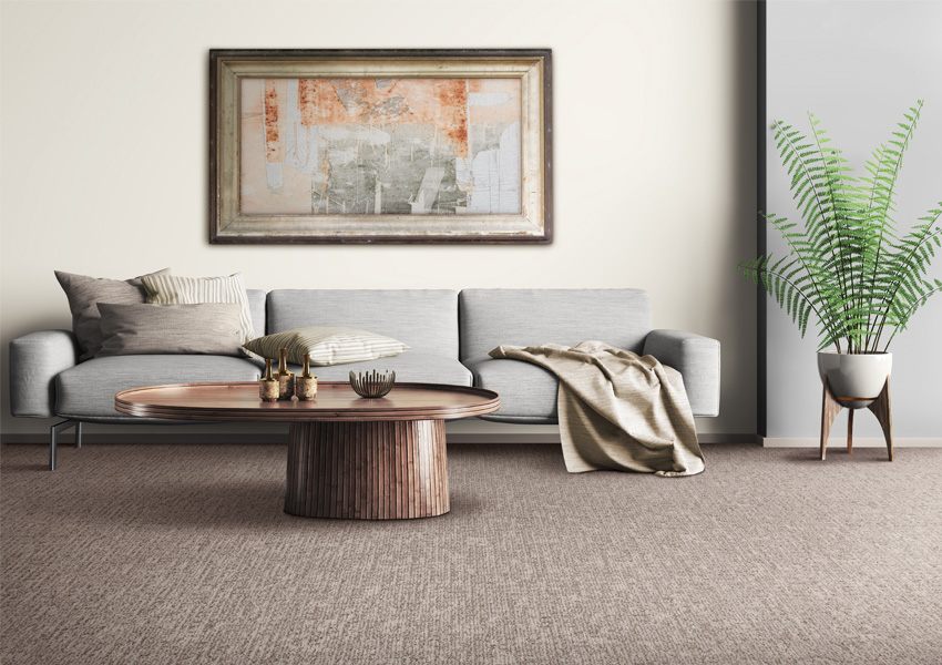 patterned carpet in living room with grey couch and wood coffee table.